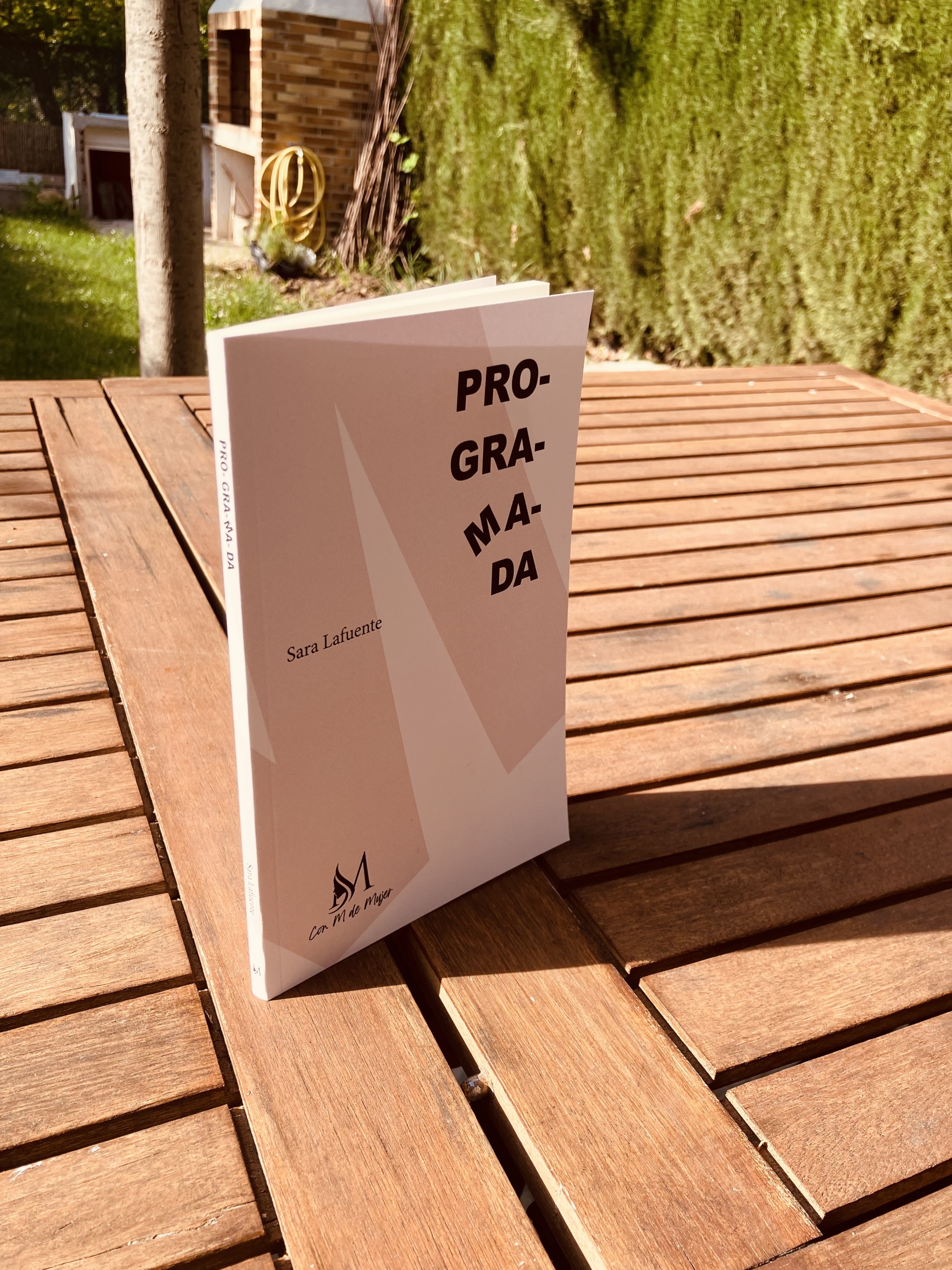 Portada del libro Programada sobre una mesa de madera